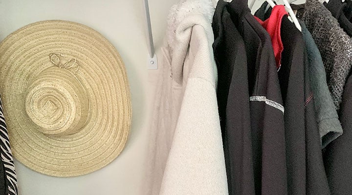 wide-brimmed hat hung on wall in closet